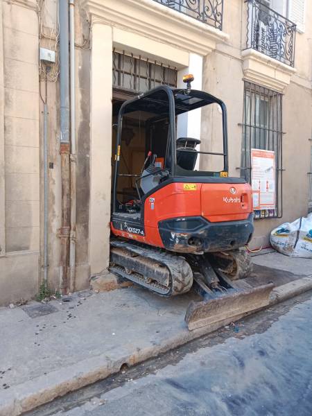 Une mini pelle 1 T devant l'entrée de l'immeuble à AIX EN PROVENCE